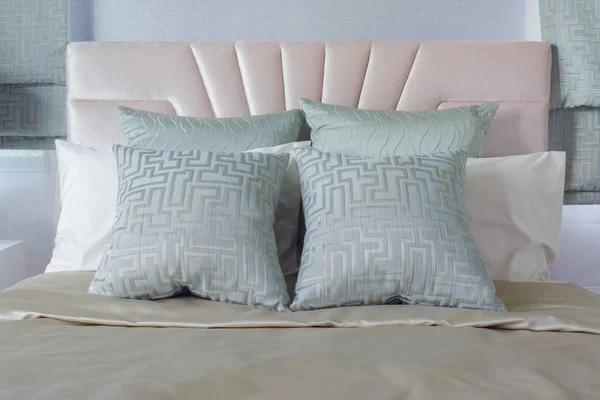 Satin färdiga kuddar på sängen med korallrosa färg sänggavel i bakgrunden — Stockfoto