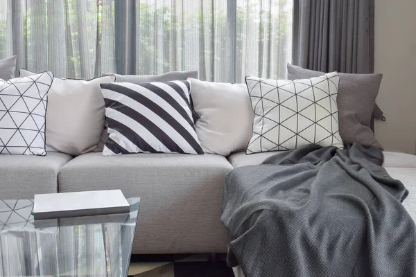 Sofá gris claro con almohadas de patrón varía en la esquina de la vida moderna —  Fotos de Stock