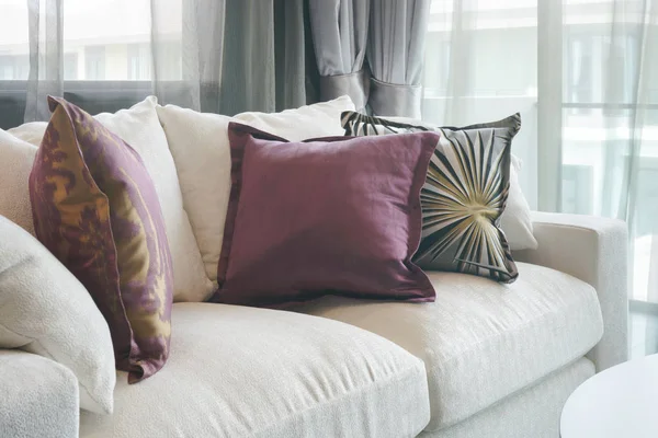 Hermosas almohadas púrpura y verde en el sofá blanco en la sala de estar — Foto de Stock