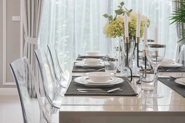 Stoviglie in stile classico moderno su tavolo da pranzo con vaso di fiori — Foto Stock