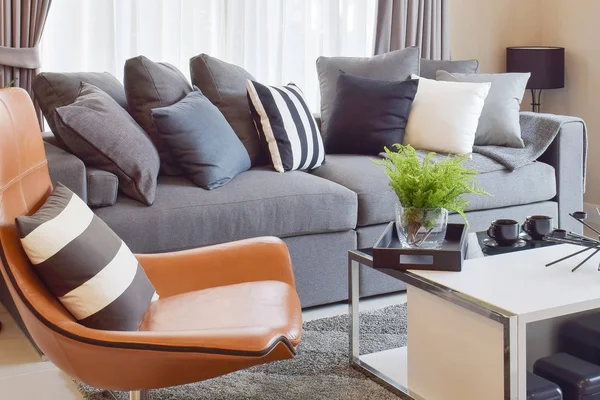 Стильный дизайн гостиной с серыми и черными полосатыми подушками на удобном диване — стоковое фото
