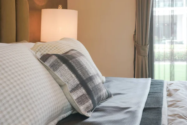 Almohadas de patrón de cuclillas en la cama en el dormitorio interior de estilo de lujo — Foto de Stock