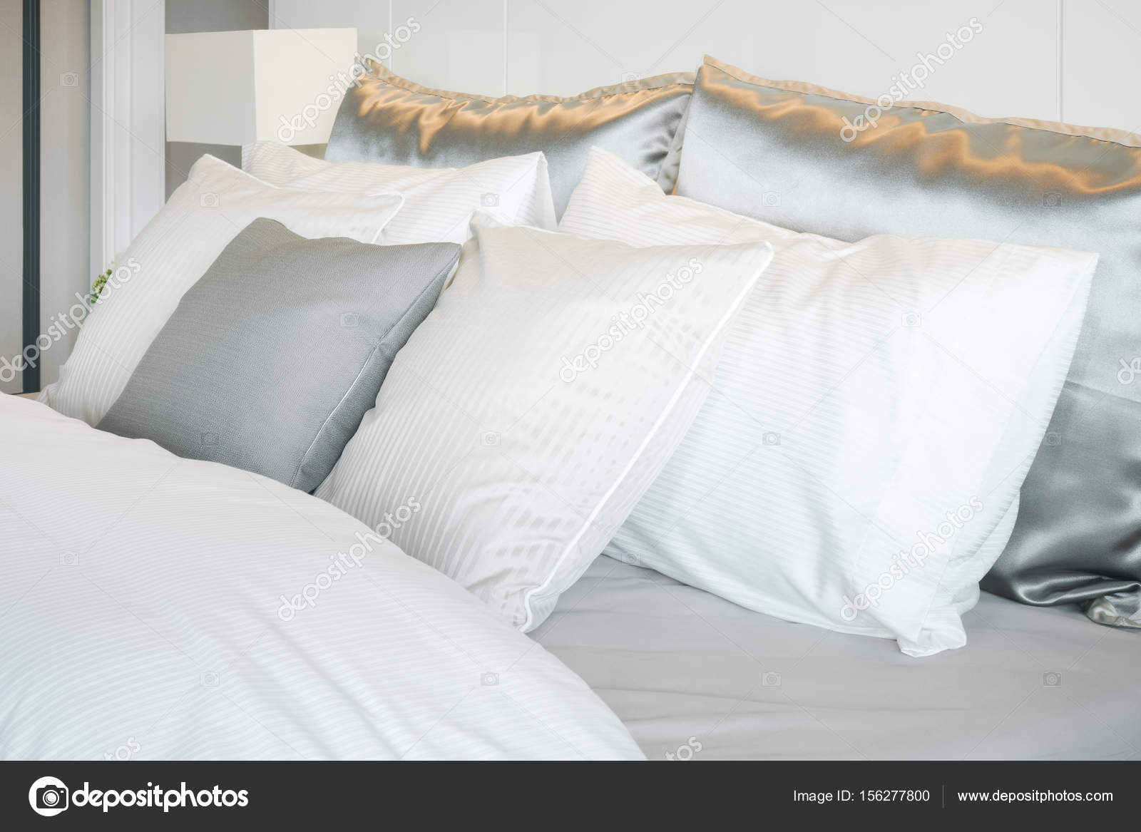Gray color scheme pillows setting on bed with satin finished style