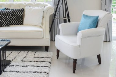 Beyaz ve mavi yastık vintage oturma odasında bir beyaz deri kanepede