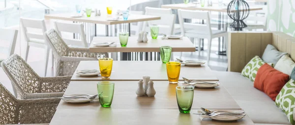 Table à manger en bois avec ensemble coloré pour le repas à l'intérieur du restaurant — Photo