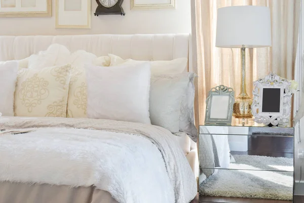 Белая лампа с рамкой на стеклянном тумбочке в роскошной спальне — стоковое фото
