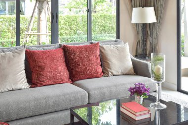 Modern oturma odası tasarımı ile kanepe ve dekoratif masa lambası kırmızı yastık