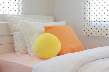 Sarı kabarık topu ve turuncu renk yastık yatak tatlı renk düzeni yatak odasında