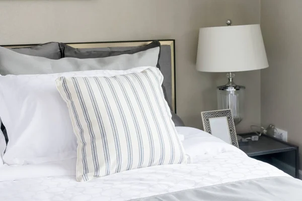 Сучасна спальня з смугастою подушкою і лампою — стокове фото