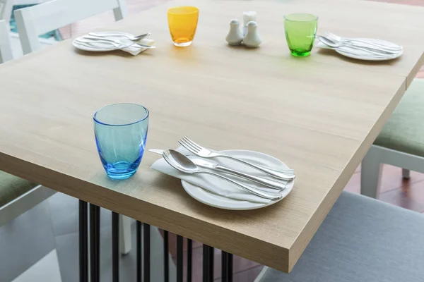 Mesa de comedor de madera con juego de colores para la comida en el interior del restaurante — Foto de Stock