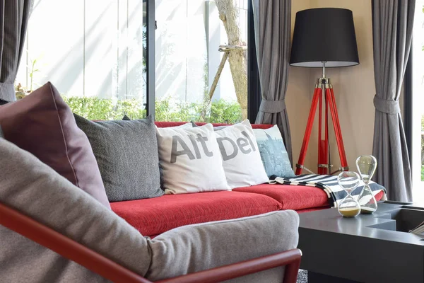 Moderno diseño de la sala de estar con almohadas en el sofá rojo y lámpara decorativa —  Fotos de Stock