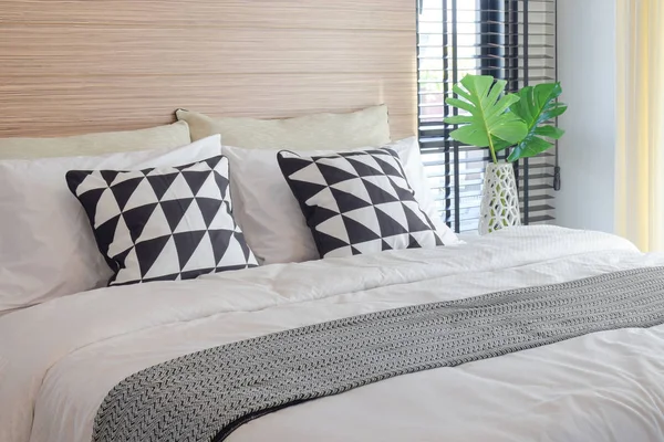 Черно-белый стиль постельного белья и хрустальная банка рядом с кроватью — стоковое фото