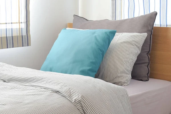 Бірюзова і сіра подушка на ліжку зі смужкою стиль постільної білизни — стокове фото