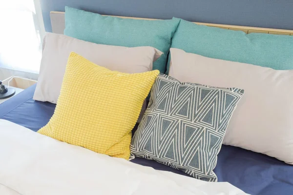 Gele en groene kussen instelling op bed met blauwe kleur bed vel — Stockfoto