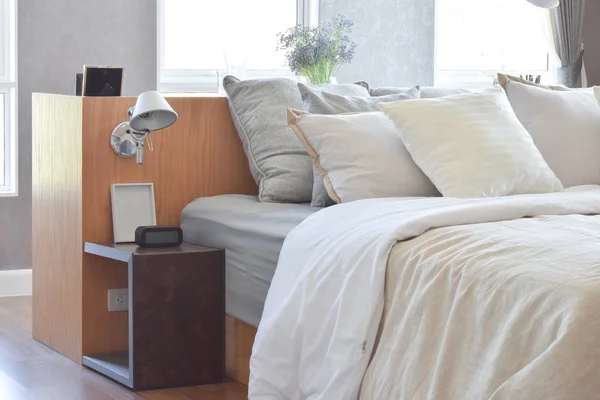 Elegante camera da letto design interno con cuscini a righe bianche sul letto e lampada da tavolo decorativa . — Foto Stock