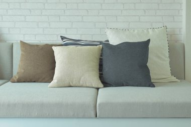 Arka planda beyaz tuğla ile bej yastık yastık duvar