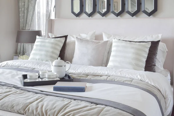 Bandeja decorativa com livro e chá na cama no quarto moderno — Fotografia de Stock