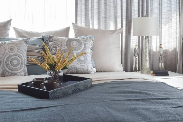 Luxury bedroom interior with striped pillows and decorative tea set on bed — Stock Photo, Image