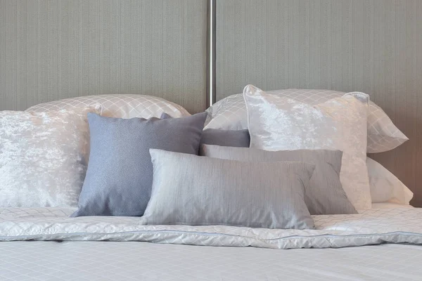 Современный интерьер спальни с серыми и полосатыми подушками на кровати — стоковое фото