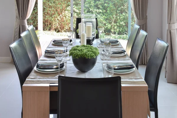 Eettafel van houten en comfortabele stoelen in modern huis met elegante tabel instellen — Stockfoto