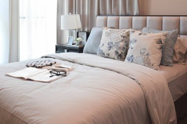 çiçek desenli yastık yatak ve dekoratif masa lambası ile şık yatak odası iç tasarım.