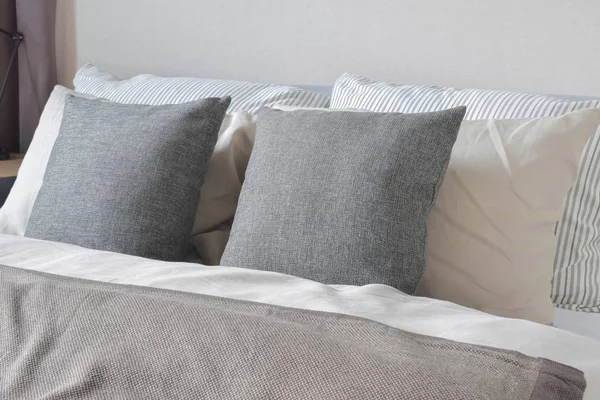 Dark gray and off white pillows setting on bed — Stock Photo, Image