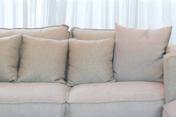 Gray pillows setting on gray sofa in living room — Stock Photo, Image