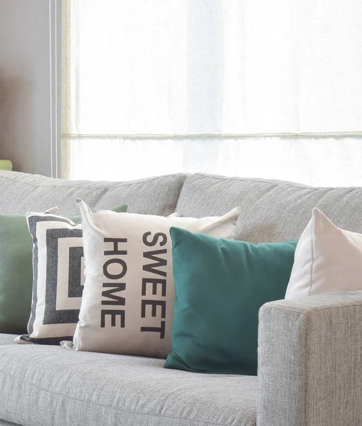 Acogedor sofá gris con almohadas de geometría patrón en la sala de estar moderna —  Fotos de Stock