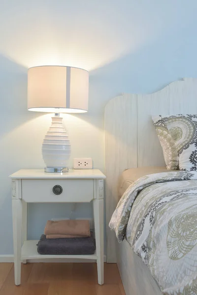 Белая лампа для чтения рядом с современным постельным бельем в стиле кантри — стоковое фото