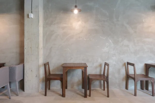 Деревянный стол и стул в ресторане с подвесным освещением — стоковое фото