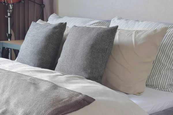 Dark gray and white pillows setting on bed with comfy blanket — Stock Photo, Image