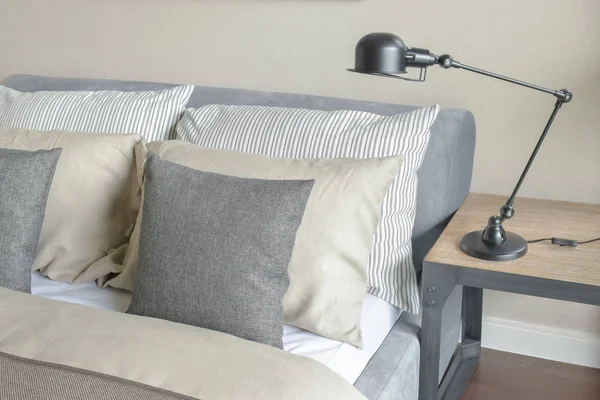 Quarto de parede marrom com travesseiros e lâmpada de leitura dobrável — Fotografia de Stock