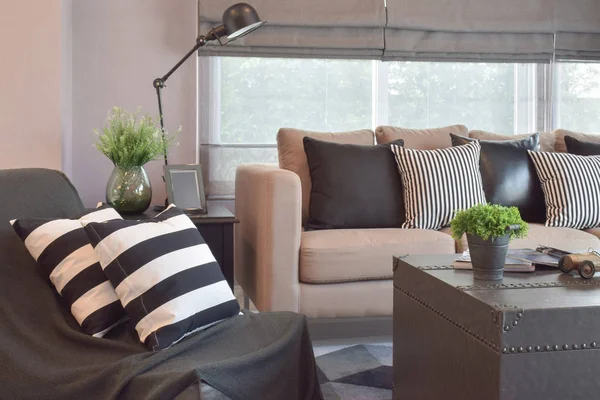 Striped and black leather pillows on the sofa in modern industrial style living room