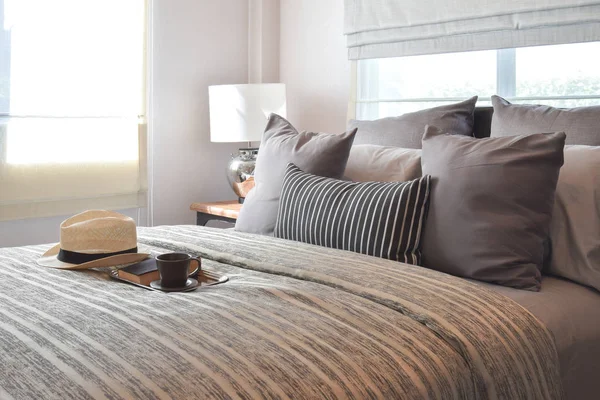 Стильний дизайн інтер'єру спальні зі смугастими подушками на ліжку та декоративною настільною лампою . — стокове фото