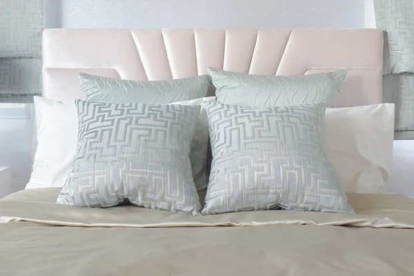 Пастельний колір подушок, встановлений на ліжку з атласною постільною білизною — стокове фото