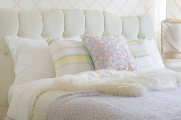 Sweet colorful pillows setting on bed with puffy scarf — Stock Photo, Image