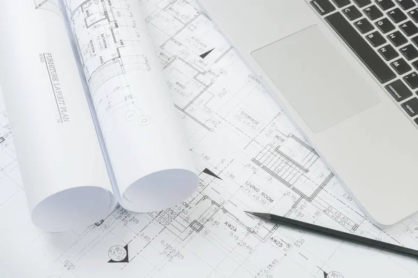 Black pencil and computer laptop on architectural drawing paper for construction — Stock Photo, Image