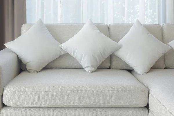 Almohadas y sofá en color beige con cortina transparente en el fondo — Foto de Stock