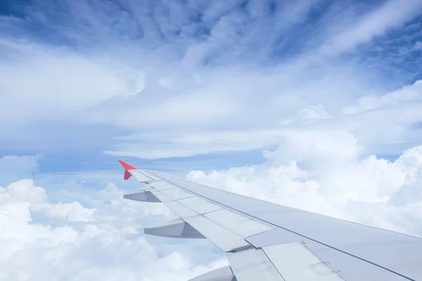 Крыло самолета на красивом драматическом небе с облаком — стоковое фото