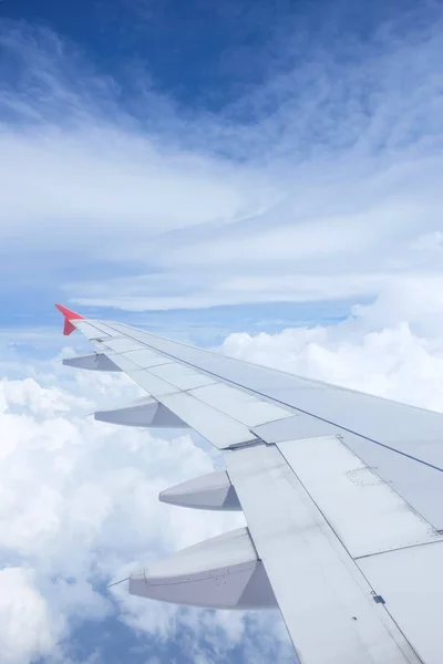 Крыло самолета на красивом драматическом небе с облаком — стоковое фото