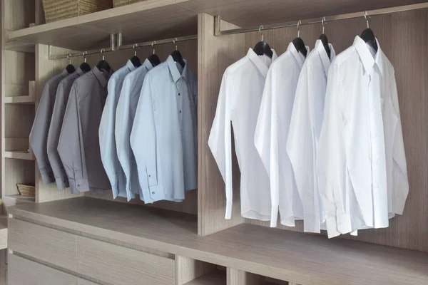 Classic color shirts hanging in warm wooden wardrobe — Stock Photo, Image