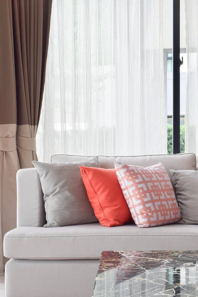 Almohadas anaranjadas y grises en sofá beige en la sala de estar — Foto de Stock