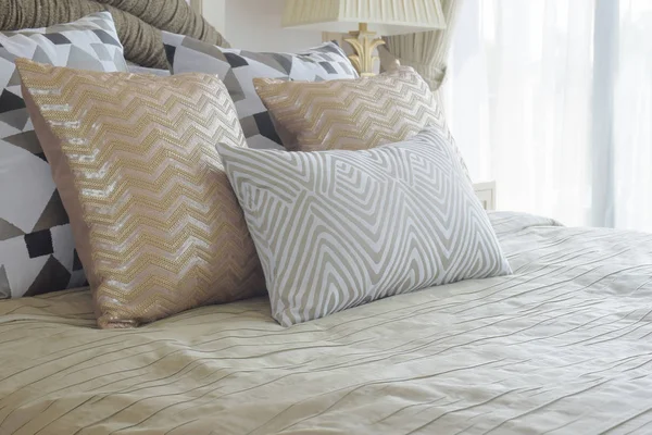 Travesseiros dourados e prateados na cama com quarto interior de estilo luxuoso — Fotografia de Stock