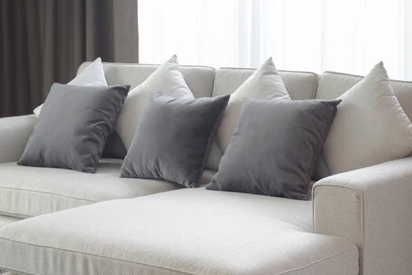 Almohadas de dos tonos yacen en el sofá beige en la sala de estar — Foto de Stock