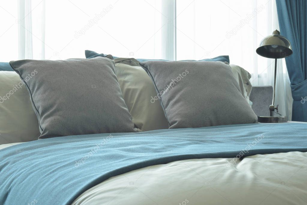 Gray pillows on bed with bed runner in blue color
