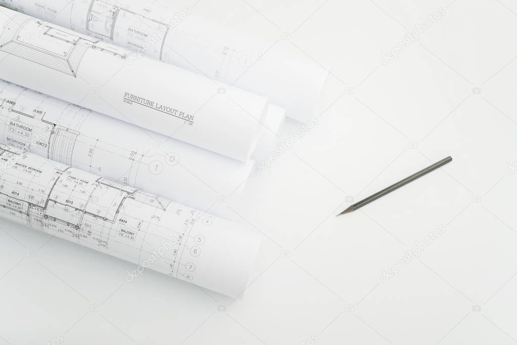 Scroll of architectural drawing and pencil on engineer's working table