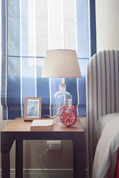 Book clock frame and reading lamp on bedside table
