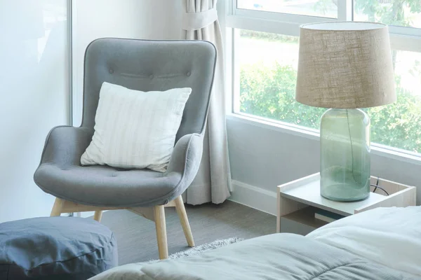 Grijze fauteuil met kussen op de hoek van de slaapkamer — Stockfoto