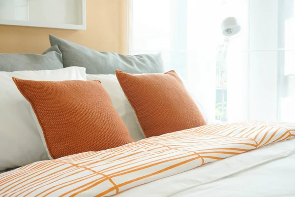Ζωντανή στιλ κλινοστρωμνή, πορτοκαλί μαξιλάρια ρύθμιση στο κρεβάτι — Φωτογραφία Αρχείου