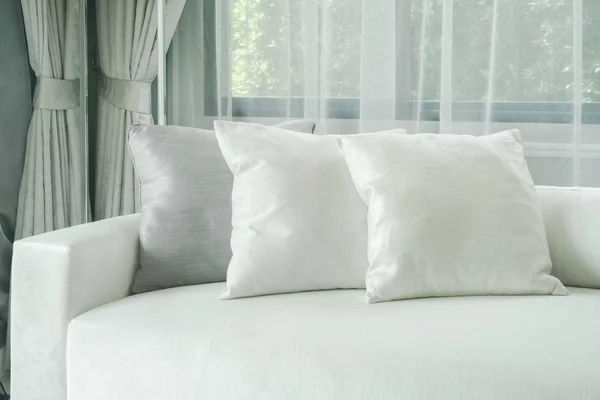 Kissen lagen auf weißem Sofa mit Vorhang im Hintergrund — Stockfoto